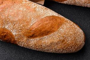 francese baguette pane su un' buio strutturato calcestruzzo sfondo foto