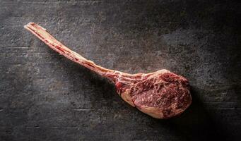 crudo tomahawk bistecca su un' vecchio rustico tavola - superiore di Visualizza. foto