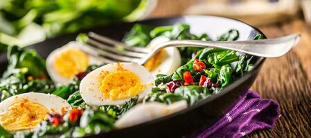 spinaci insalata. fresco spinaci insalata con uova chili Pepe e dolce mirtilli. foto