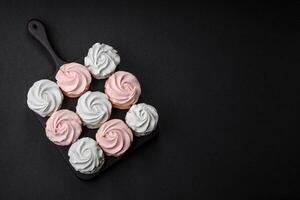 delizioso dolce multicolore marshmallow su un' buio calcestruzzo sfondo foto