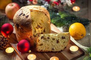 delizioso Panettone su Natale tavolo spirito decorazioni e Avvento ghirlanda e candele foto