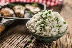 riso basmati con verde piselli nel ciotola e grigliato pollo Seno nel il sfondo foto