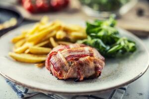 jamon avvolgere di Brie formaggio con francese patatine fritte e verdura su un' piatto foto