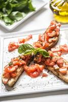 gustoso italiano aperitivo Bruschetta su piatto con oliva olio foto