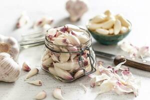 rustico vaso pieno su con aromatico aglio Chiodi di garofano su il bianca scrivania foto