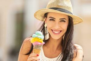 bellissimo contento donna con colorato ghiaccio crema durante un' caldo estate giorno foto