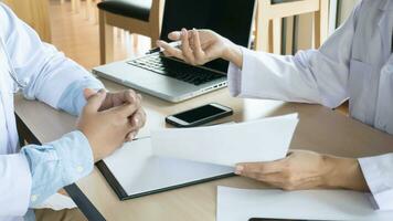 medico assistenza sanitaria. professionale medico medico nel bianca uniforme toga cappotto colloquio consulenza paziente rassicurante il suo maschio paziente porzione mano foto