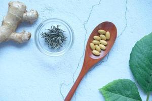 fitoterapia sul cucchiaio ed erbe aromatiche sul tavolo foto