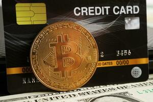 bitcoin dorato con carta di credito su banconote in dollari statunitensi denaro per affari e commerciali, valuta digitale, criptovaluta virtuale. foto