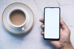 primo piano della mano del giovane che utilizza smartphone con schermo vuoto foto