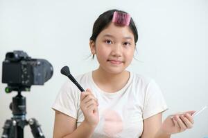 carino asiatico ragazza blogger è mostrando Come per rendere su e uso cosmetici. foto
