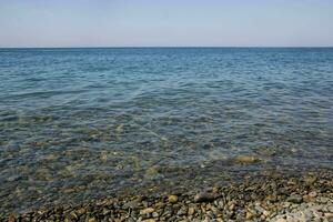 calma blu mare onde morbido superficie oceano e blu cielo sfondo foto