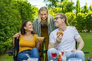 famiglia con madre e sua bambini Compreso fratello e sorella avendo bbq picnic vacanza a loro Giardino dietro la casa durante estate mentre avendo bene cibo e tempo insieme per amore e fratello concetto foto