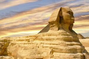 testimone il travolgente bellezza di il egiziano sfinge, in piedi con grazia contro il fondale di un' maestoso tramonto nel giza. foto