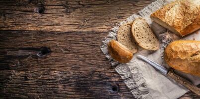 bandiera Visualizza di Due fette di croccante al forno pane su un' Vintage ▾ stoffa e di legno sfondo con un' coltello su il lato foto