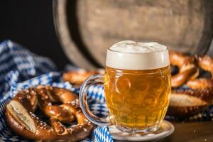 oktoberfest birra con salatino di legno barile e blu tovaglia foto