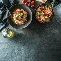 superiore di Visualizza italiano pasta spaghetti bolognese nel piatto e padella con pomodori e basilico foto