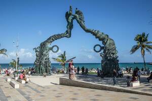 portale maya, Messico. marzo 19. 2022. portale maya scultura nel playa del Carmen nel quintana roo nel Messico con abbondanza di turisti seduta in giro e un' coppia in piedi sotto esso foto