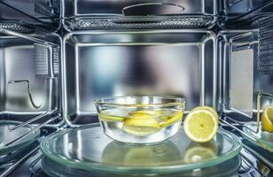 un' metodo di pulizia nel un' microonde forno con acqua e Limone foto