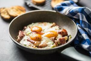 inglese prima colazione fritte Bacon prosciutto e uova nel ceramica padella foto