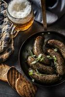 arrostito salsicce nel padella con pane erbe aromatiche e bozza birra. foto