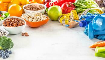 selezione di salutare Alimenti, la verdura, frutta, mandorle, insalata, esercizio utensili e misurazione nastro foto