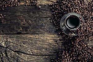 tazza di nero caffè con fagioli su di legno tavolo foto