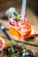 cocktail bevanda su un' vecchio di legno tavola. alcolizzato bevanda con tropicale frutta rosso Pepe erba e ghiaccio foto