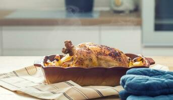 arrostito totale pollo con patate nel cottura al forno piatto. gustoso cibo a casa su il cucina contatore foto