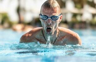 un' maschio nuotatore nuotate nuoto a rana nel un' nuoto piscina durante formazione per un' Triathlon foto