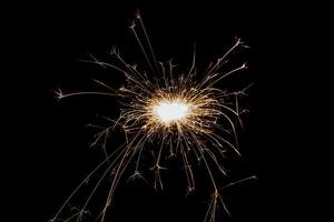 scintillante in fiamme isolato su sfondo nero. tema fuochi d'artificio. effetto luce e consistenza. foto