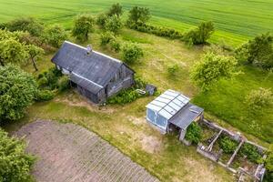 panoramico aereo Visualizza di eco villaggio con di legno case, ghiaia strada, giardini e frutteti foto