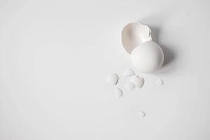 Guscio d'uovo bianco di un uovo di gallina rotto con cocci isolati su uno sfondo bianco