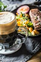 bicchiere di buio birra nel pub o ristorante su tavolo con delicoius cibo foto