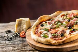 italiano Pizza con prosciutto pomodori olive oliva olio parmigiano formaggio e rucola. foto