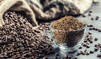 granuli di immediato caffè nel bicchiere tazza e caffè fagioli. foto