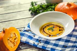 zucca crema la minestra con semi e prezzemolo su cucina tavolo foto