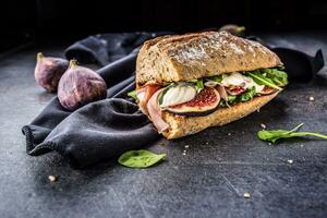 Sandwich con fichi prosciutto spinaci rucola e formaggio tuffo foto