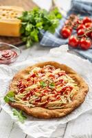 gustoso fritta langos servito su cottura al forno carta con un' lotto di grattugiato formaggio, ketchup e fresco erbe aromatiche foto