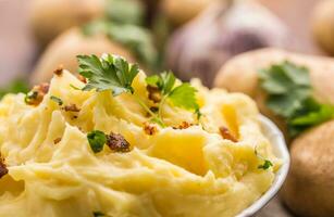 schiacciato patate nel ciotola decorato con prezzemolo erbe aromatiche. foto