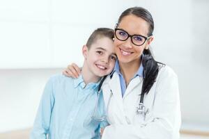 contento pediatra femmina medico e giovane ragazzo nel ambulanza. persone e pediatria concetto foto