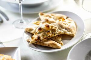 focaccia piadina fette con rosmarino appena al forno e affettato per triangoli foto