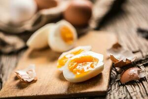 avvicinamento bollito o crudo pollo uova su di legno tavola foto