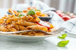 italiano cibo e pasta pene con bolognese salse su piatto foto