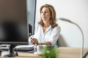 un contabile o donna d'affari lavori nel sua ufficio a un' computer foto