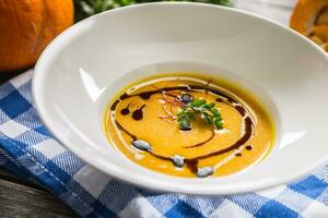 zucca crema la minestra con semi e prezzemolo su cucina tavolo foto