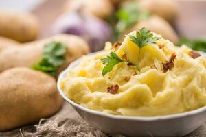 schiacciato patate nel ciotola decorato con prezzemolo erbe aromatiche. foto