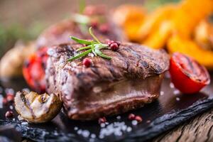 grigliato Manzo bistecca con rosmarino, sale e Pepe su vecchio taglio tavola. Manzo filetto di manzo bistecca. foto