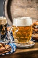 oktoberfest birra con salatino di legno barile e blu tovaglia foto