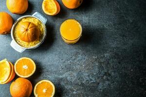 fresco arance spremiagrumi succo e tropicale frutta su calcestruzzo tavola foto